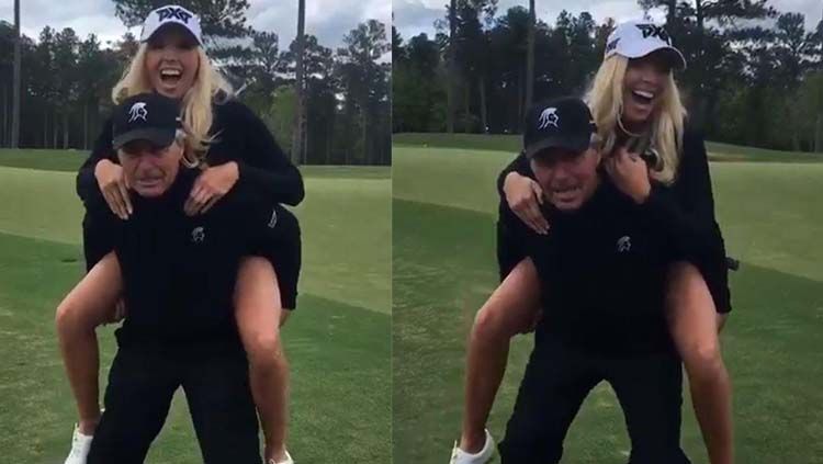 Mantan pegolf asal Afrika Selatan, Gary Player memamerkan kekuatannya dengan menggendong seorang pegolf cantik. Copyright: &copy; Twitter @ELISSELOB