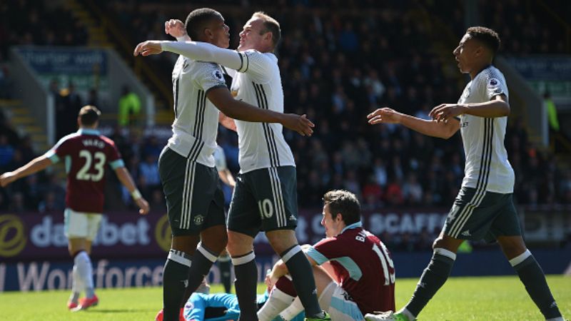 Martial (kiri) dan Rooney berpelukan merayakan golnya. Copyright: &copy; OLI SCARFF / Stringer / Getty Images