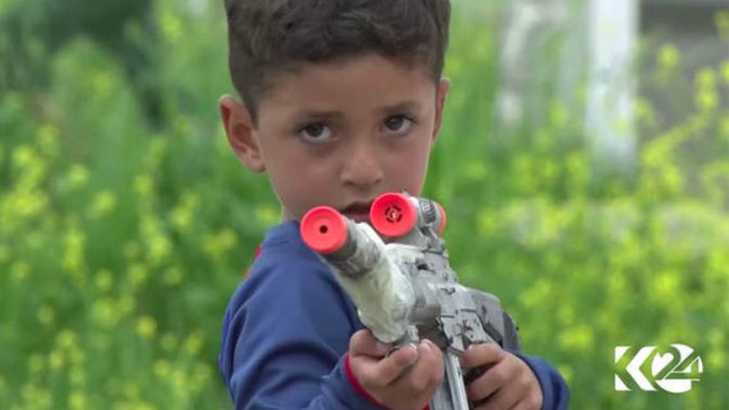 Anak kecil asal Irak yang bernama Messi, menodongkan pistol mainan. Copyright: © Kurdistan24