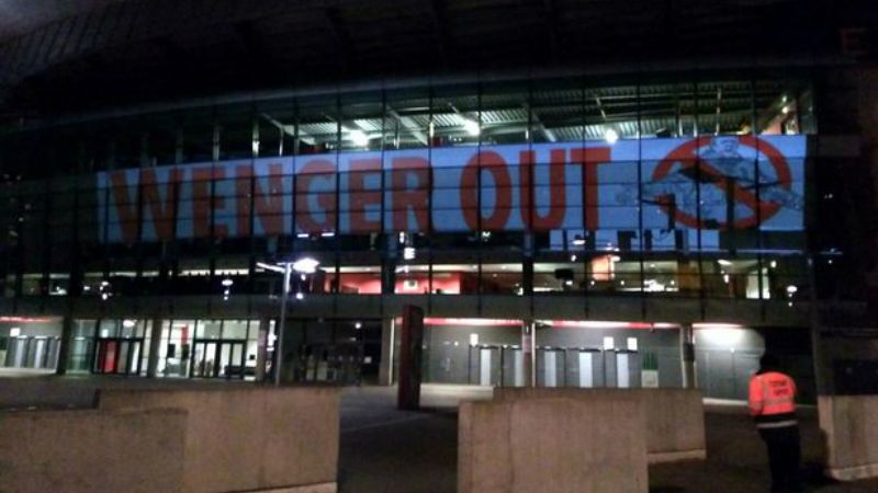 Lampu sorot Wenger Out terlihat di bagian samping Emirates Stadium. Copyright: © Mirror