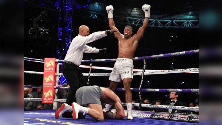 Wladimir Klitschko tampak di bawah kaki Anthony Joshua yang tengah melakukan selebrasi. Copyright: &copy; @PA