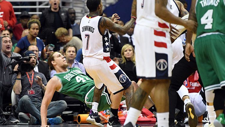 Center Boston Celtics, Kelly Olynyk didorong ke lantai oleh pemain Washington Wizards. Copyright: © Greg Fiume/Getty Images