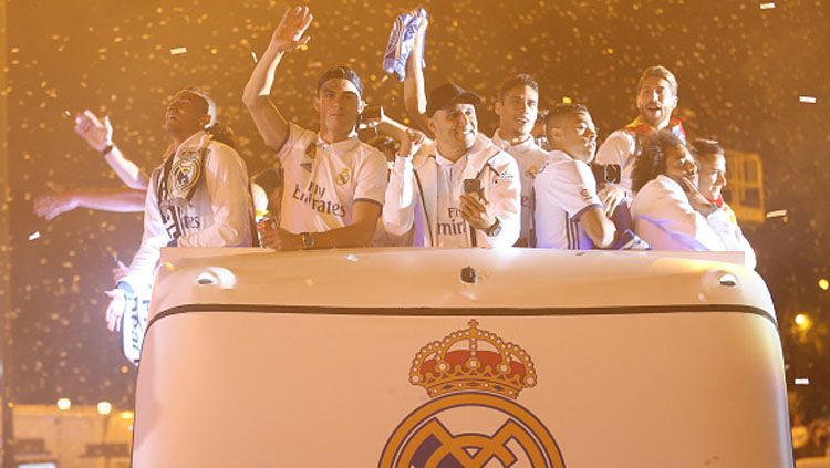 Stiker Real Madrid, Cristiano Ronaldo, dan rekannya tampak melambaikan tangannya kepada fans yang tengah mengikuti parade kemenangan. Copyright: © Raddad Jebarah/NurPhoto via Getty Images