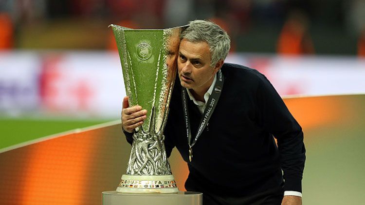 Jose Mourinho tengah memeluk trofi Liga Europa 2016/17. Copyright: © Amin Mohammad Jamali/Getty Images