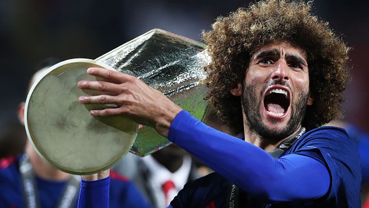 Semangatnya Marouane Fellaini melakukan selebrasi bersama trofi Liga Europa. Copyright: © Ian MacNicol/Getty Images