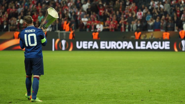 Wayne Rooney selebrasi dengan trofi Liga Europa. Copyright: © Twitter@EuropaLeague
