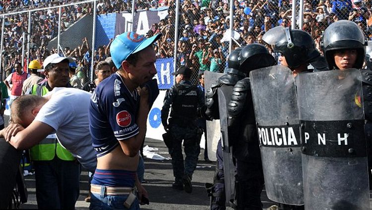 Polisi tampak berjaga ketat melawan fans yang nekat masuk stadion. Copyright: © AFP/Getty Images