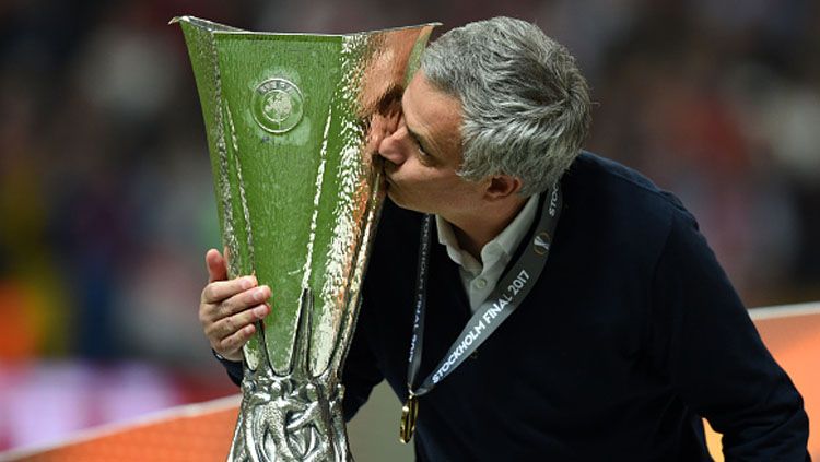 Jose Mourinho saat mencium trofi liga Europa. Copyright: © getty images
