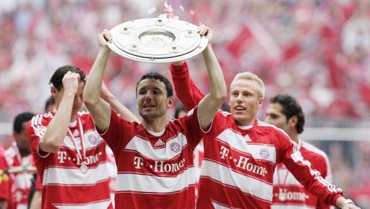 Mark van Bommel (tengah) mengangkat trofi Bundesliga. Copyright: © INDOSPORT