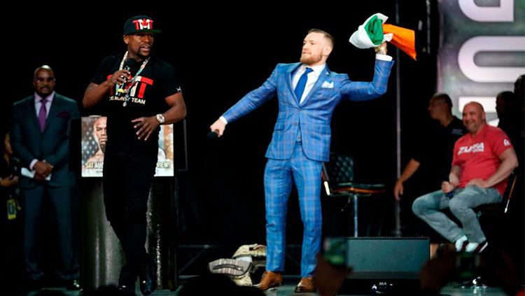 Conor McGregor melempar bendera Irlandia ke wajah Floyd Mayweather. Copyright: © The Sun