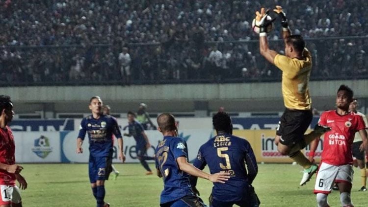 Andritany Ardhiyasa berhasil mengamankan bola dari serangan Persib Bandung. Copyright: © @kumparan