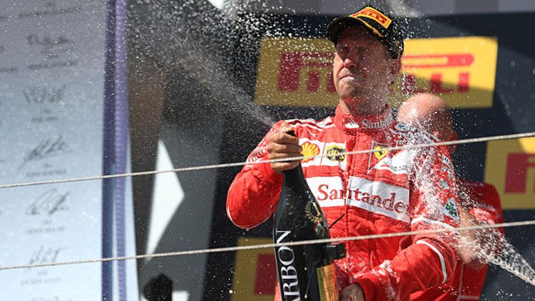 Sebastian Vettel selebrasi dengan menyemprotkan bir. Copyright: © INDOSPORT