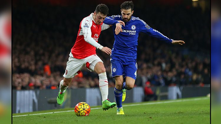 Mesut Ozil (kiri/Arsenal) saat berduel dengan Cesc Fabregas (Chelsea). Copyright: © Getty Images