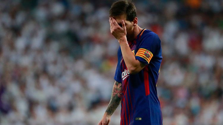 Lionel Messi menutup wajahnya usai Barcelona takluk dari Real Madrid. Copyright: © Getty Images