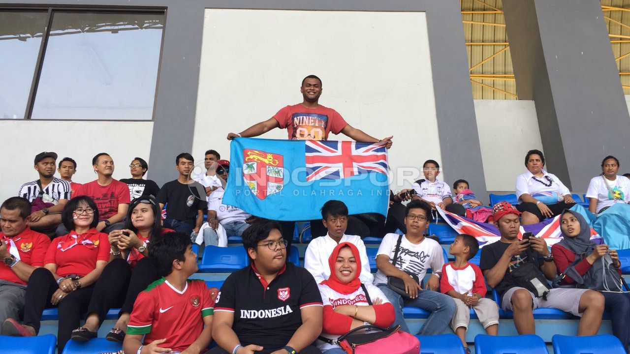 Suporter Timnas Fiji memegang bendera Fiji, hadir di Stadion Patriot. Copyright: © INDOSPORT/Muhammad Adiyaksa