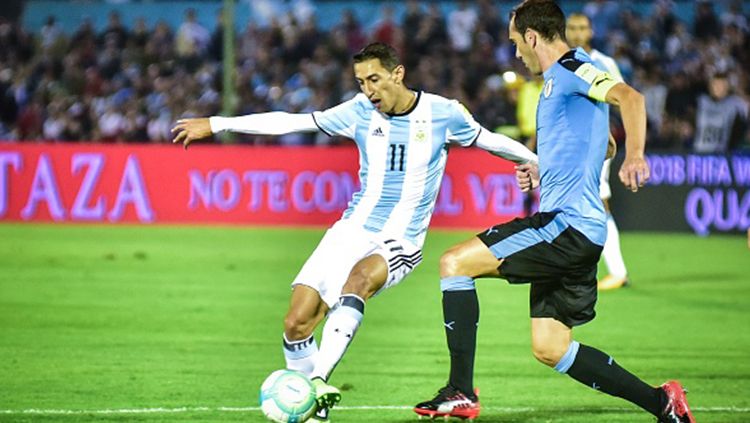 Angel di Maria mengontrol bola di depan Diego Godin. Copyright: © getty images