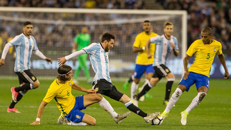 Lionel Messi tengah berusaha mengambil bola dari pemain Brasil. Copyright: © getty images