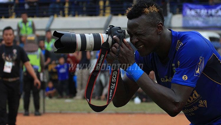 Selebrasi membidik kamera yang dilakukan Ezechiel N’Douassel usai mencetak gol ke gawang Semen Padang. Copyright: © Bobotoh.id