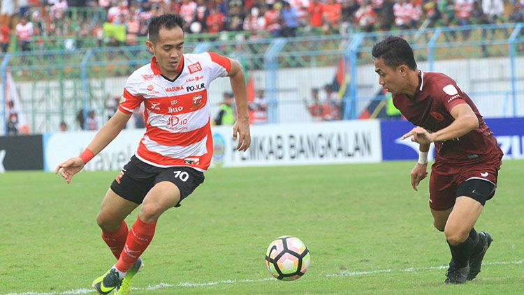 Pemain Madura United, Slamet Nurcahyo (kiri) berusaha melewati hadangan pemain lawan. Copyright: © Ian Setiawan/INDOSPORT