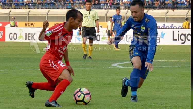 Riko Simanjuntak, gelandang sayap Semen Padang (kiri) saat berduel melawan gelandang Persib Bandung, Shohei Matsunaga. Copyright: © Taufik Hidayat/INDOSPORT