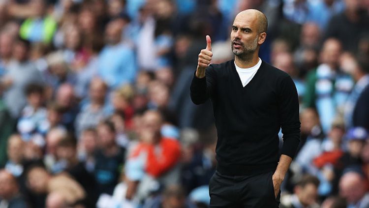 Pep Guardiola memberikan acungan jempol untuk tim besutannya dari pinggir lapangan. Copyright: © getty images