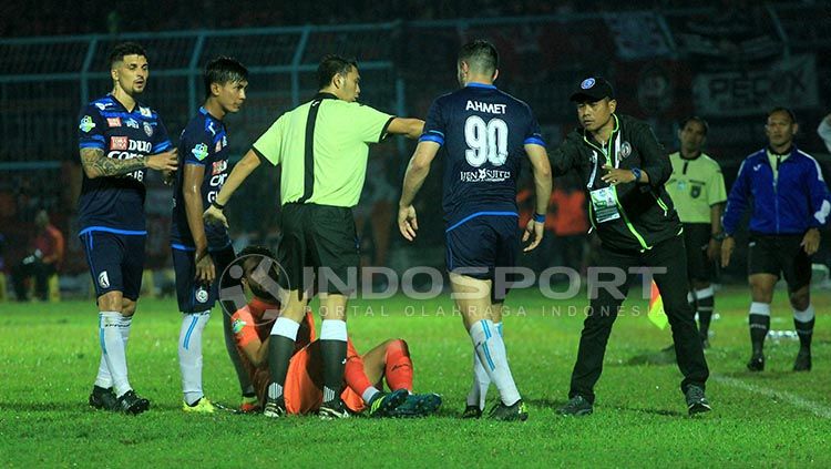 Wasit Yudi Nurcahya sigap melerai serbuan pemain Arema kepada William Pacheco, lantaran berpura-pura cedera untuk memperlambat waktu. Copyright: © Ian Setiawan/INDOSPORT