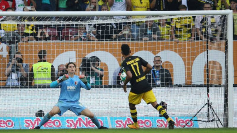 Panenka Pierre-Emerick Aubameyang yang terbaca dengan baik oleh kiper Augsburg. Copyright: © INDOSPORT