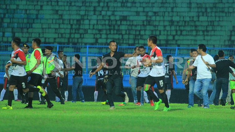 Ilustrasi citra buruk sepakbola Indonesia (Puluhan anggota polisi termasuk intel, berusaha mengamankan tawuran massal di sepakbola nasional). Copyright: © Ian Setiawan/INDOSPORT