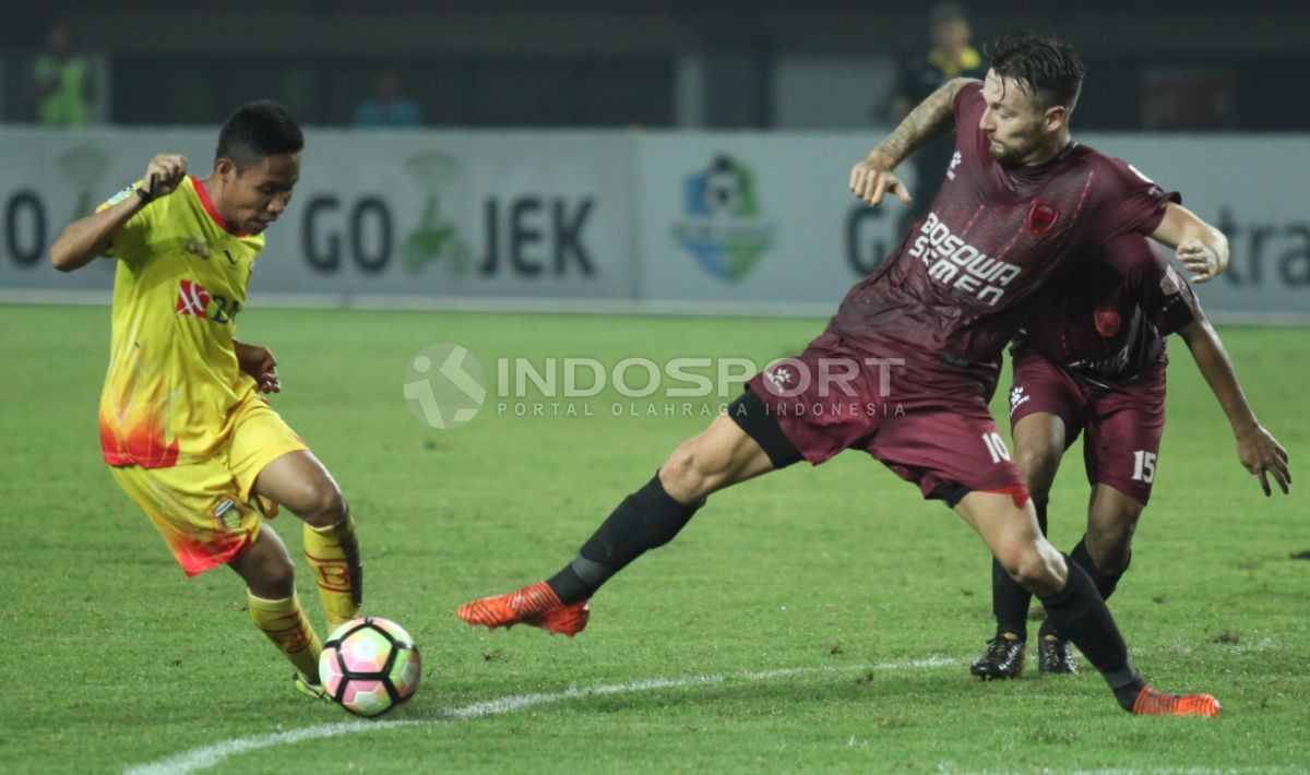 Duel antara Evan Dimas (kuning) dengan Marc Anthony Klok. Copyright: © Herry Ibrahim/INDOSPORT