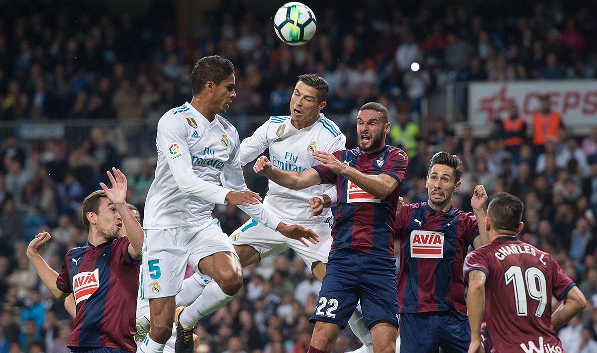 Duel udara Cristiano Ronaldo dan Raphael Varane (Real Madrid) dengan pemain Eibar. Copyright: © INDOSPORT