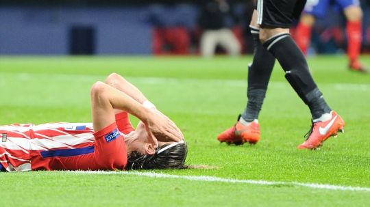 Felipe Luis tampak putus asa saat ia terbaring di rumput sambil memegangi kepalanya. Copyright: © Daily Mail