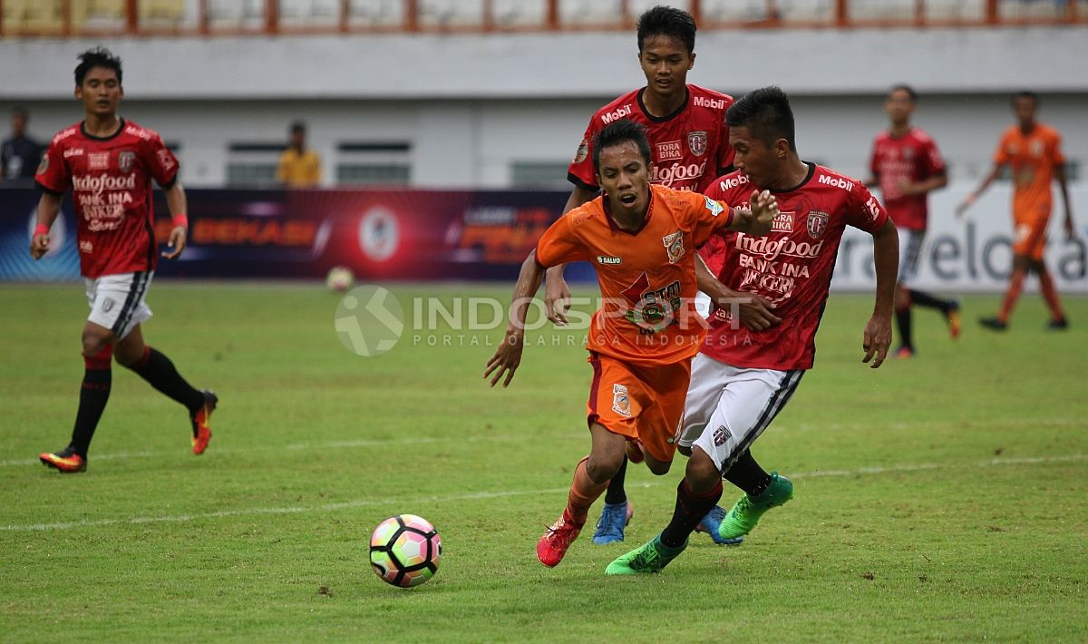 Pemain Bali United U-19 tampak menjegal pemain Borneo FC U-19 yang tengah berusaha mendapatkan bola. Herry Ibrahim/INDOSPORT Copyright: © Herry Ibrahim/INDOSPORT