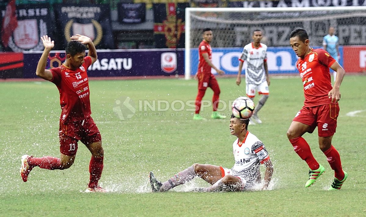 Pemain Martapura FC terjatuh saat berlawanan dengan salah satu pemain Persis Solo. Herry Ibrahim/INDOSPORT Copyright: © Herry Ibrahim/INDOSPORT