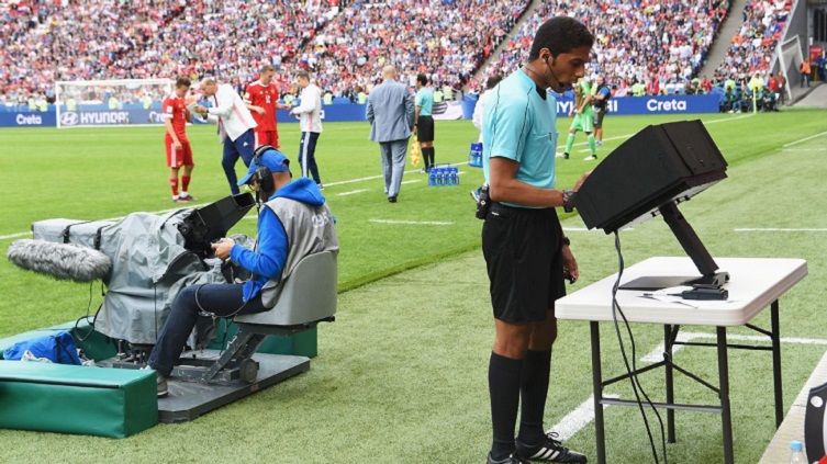 Wasit sedang menggunakan VAR di pertandingan. Copyright: © Google