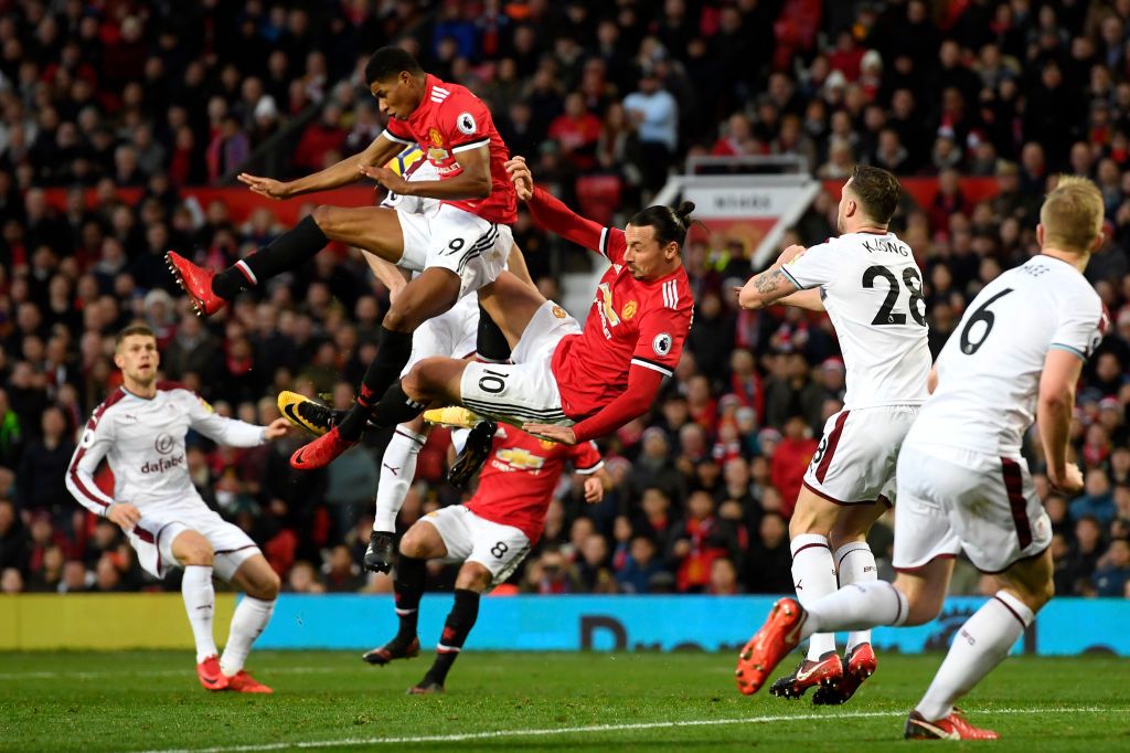 Rashford dan Ibra adu lompat untuk menendang bola. Copyright: © Getty Images