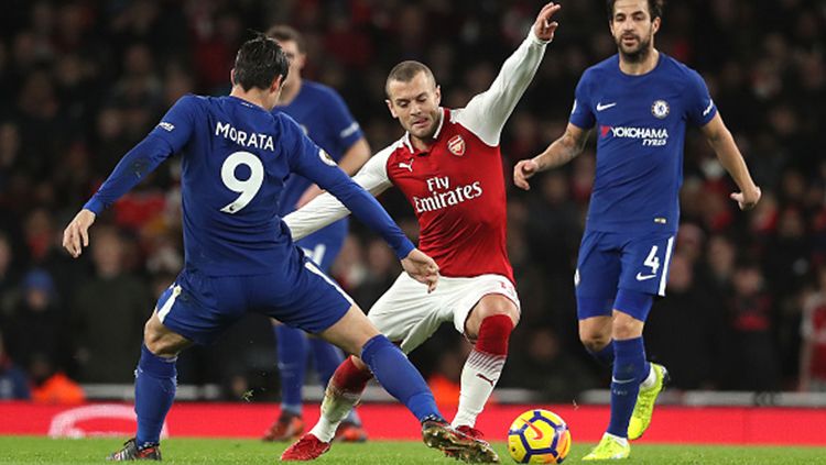 Jack Wilshere berusaha mengamankan bola dari Alvaro Morata. Copyright: © Getty Images