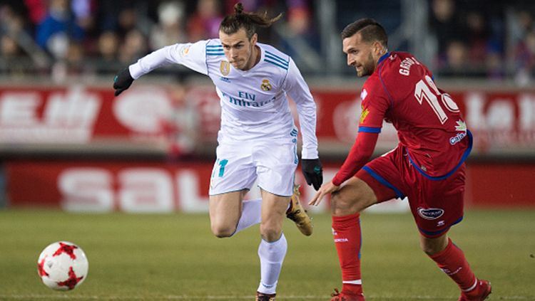 Gareth Bale sedang berebut bola dengan pemain Numancia. Copyright: © Getty Images