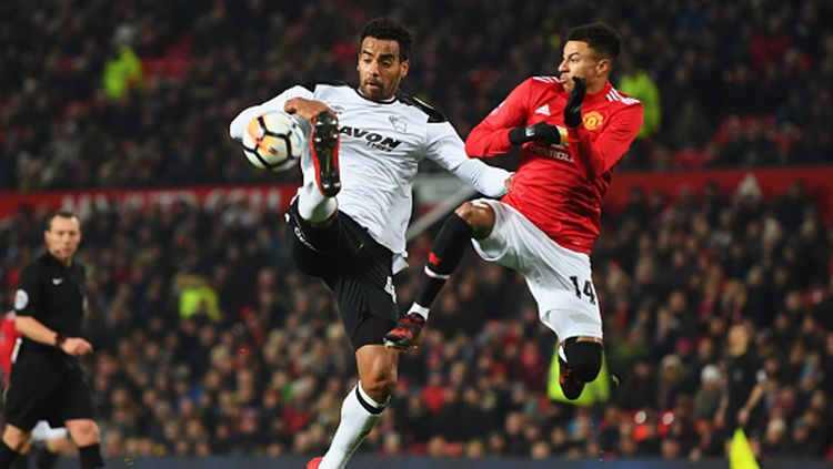 Jesse Lingard (kanan) berebut bola dengan Tom Huddlestone,  pemain Derby County. Copyright: © Getty Images