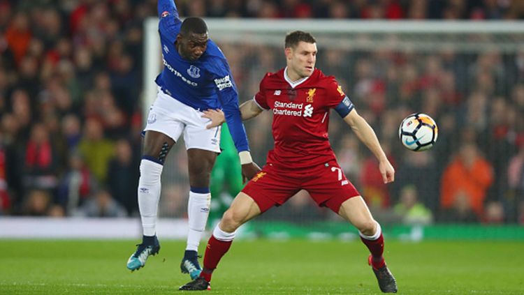 James Milner (kanan) berebut bola dengan pemain Everton. Copyright: © Getty Images