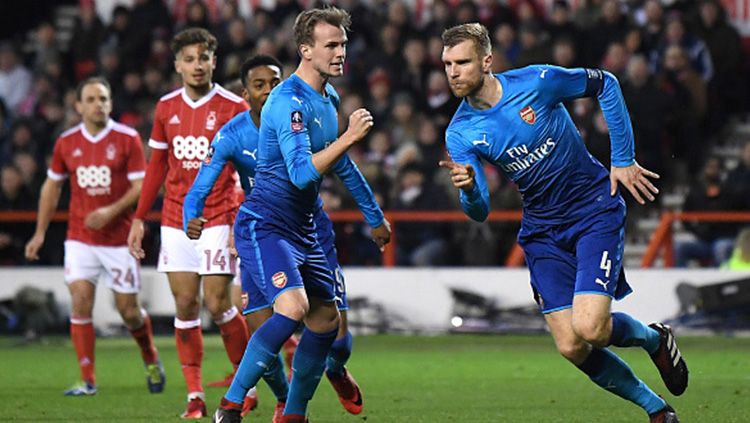 Per Mertesacker yang berselebrasi usai melawan Nottingham Forest. Copyright: © Getty Images