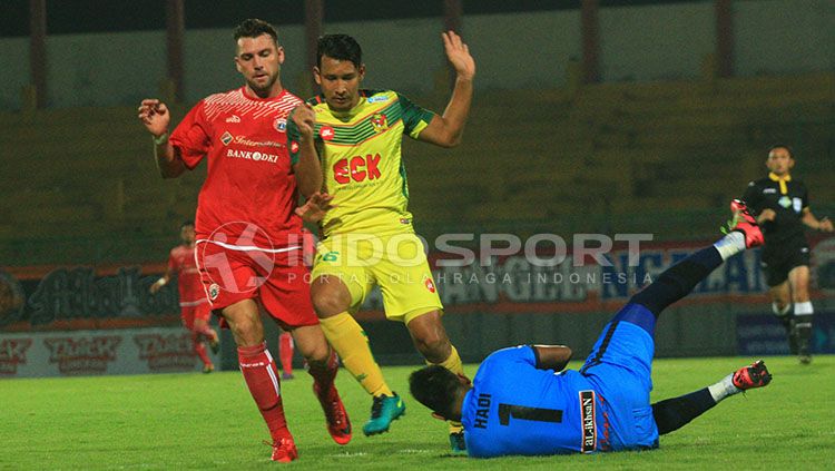 Osman Yusoff berusaha melindungi kipernya, Abdul Hadi Hamid saat menangkap bola tendangan Marko Simic. Copyright: © Ian Setiawan/INDOSPORT