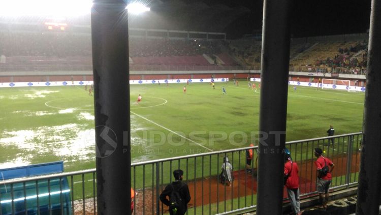 Ilustasi lapangan sepakbola yang becek akibat hujan. Copyright: © Zainal Hasan/INDOSPORT
