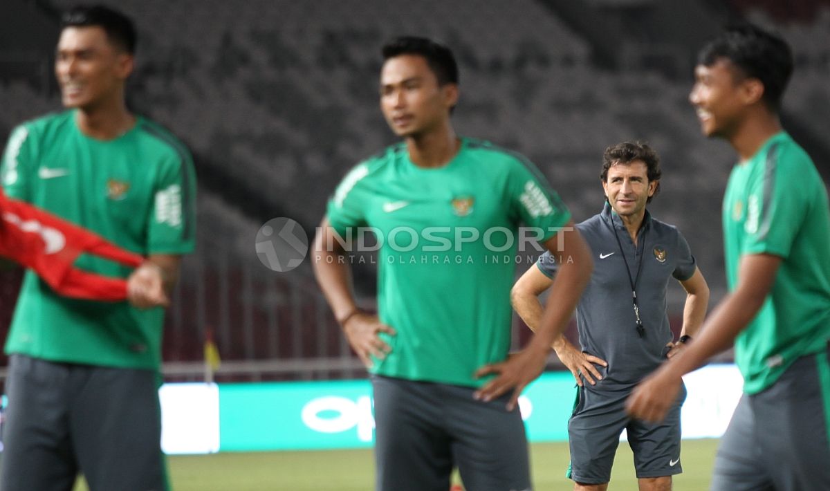 Pelatih Luis Milla (belakang) tersenyum mengamati para pemainnya berlatih. Copyright: © Indosport/Herry Ibrahim