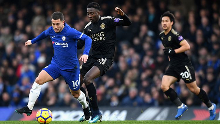 Eden Hazard (kiri) mencoba mempertahankan bola dari pemain Leicester City. Copyright: © Getty Images