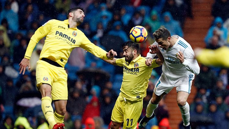 Christiano Ronaldo (kanan) sedang berebut bola dengan pemain Villareal. Copyright: © Getty Images