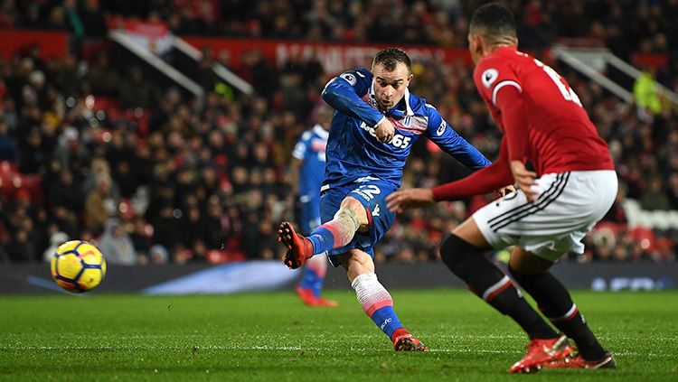 Xherdan Shaqiri (kiri) berusaha melepaskan sepakan keras ke gawang Man United. Copyright: © Getty Images