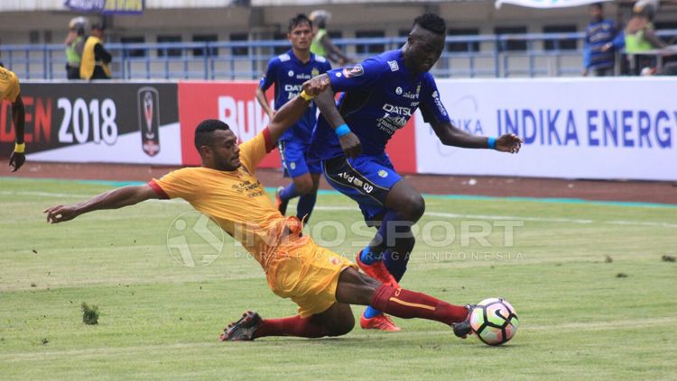 Marco Sandy (Sriwijaya FC) berusaha menggagalkan aksi Ezechiel N'Douassel. Copyright: © Arif Rahman/INDOSPORT
