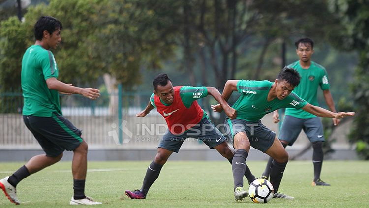 Perebutan bola antara bek anyar Timnas U-23, Rachmat Irianto dengan rekannya. Copyright: © Herry Ibrahim/INDOSPORT