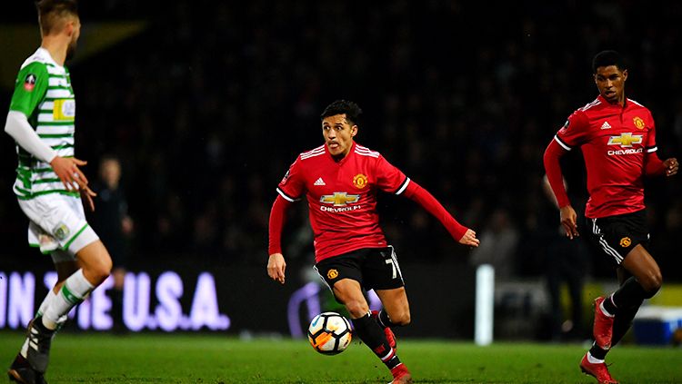 Alexis Sanchez tampak fokus dengan menggiring bola dan disusul oleh Marcus Rashford. Copyright: © Getty Images