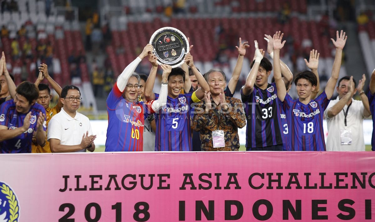 Para pemain FC Tokyo mengangkat piala kemenangan atas uji coba dalam merayakan 60 tahun Hubungan Diplomatik Indonesia-Jepang. Copyright: © Herry Ibrahim/Indosport.com